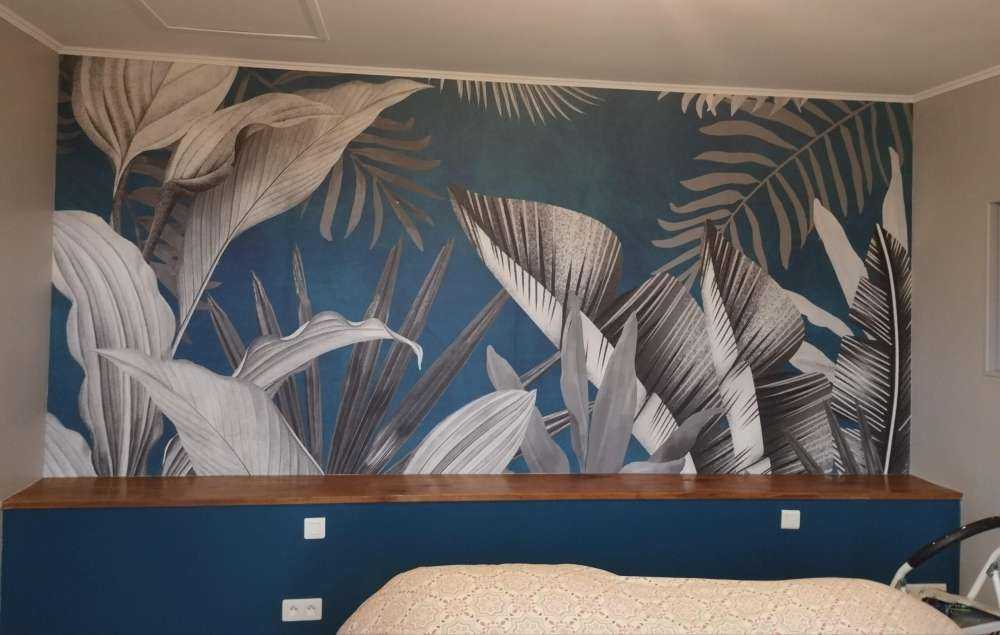 Feuilles tropicales sur fond bleu canard