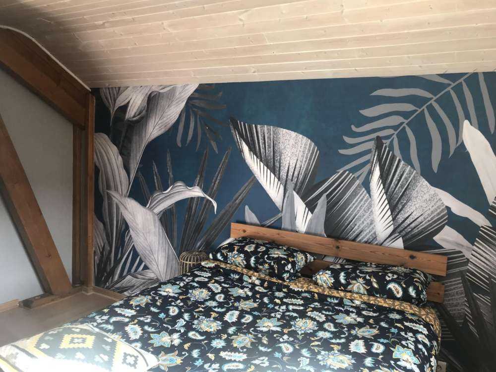 Feuilles tropicales sur fond bleu canard