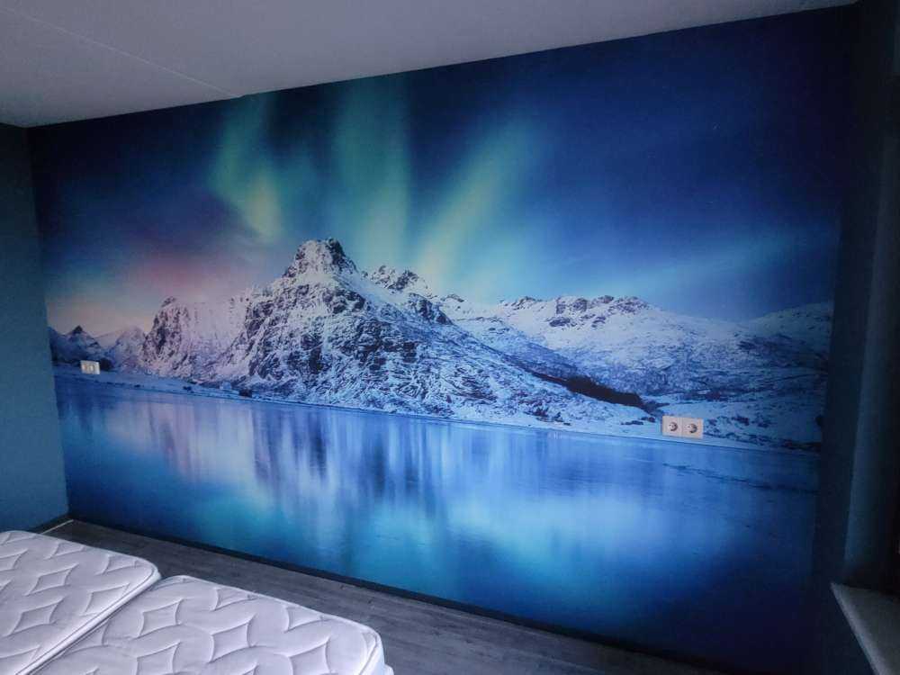 Des aurores boréales au-dessus d'un océan et de montagnes gelés