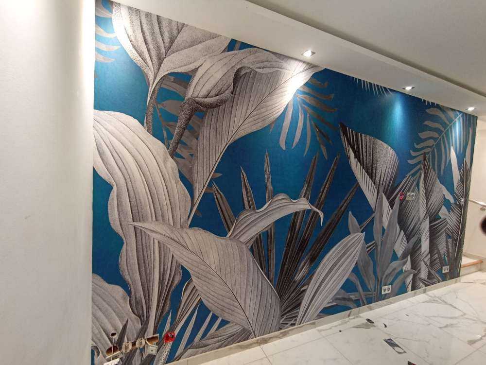 Feuilles tropicales sur fond bleu canard