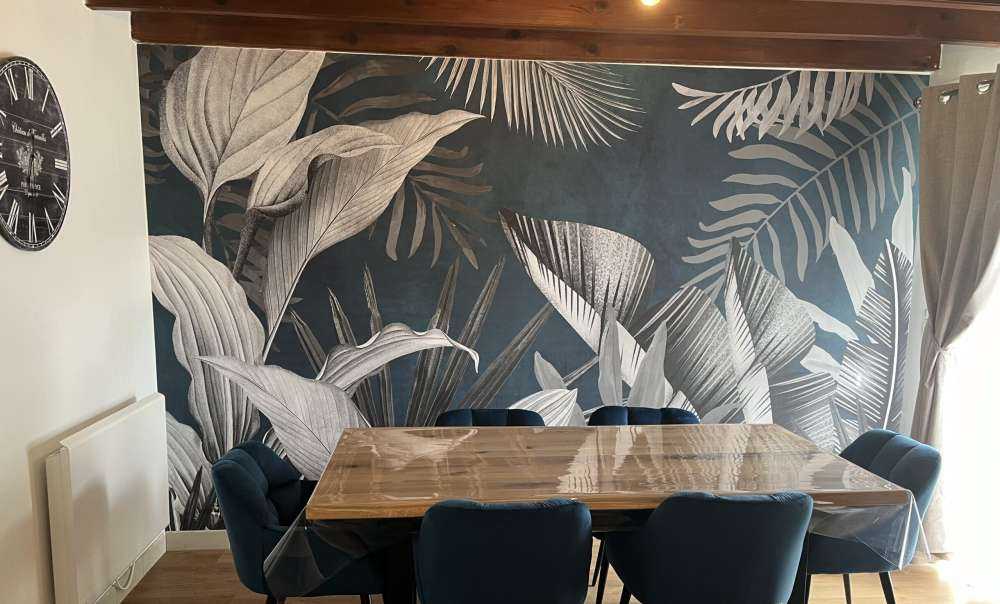 Feuilles tropicales sur fond bleu canard