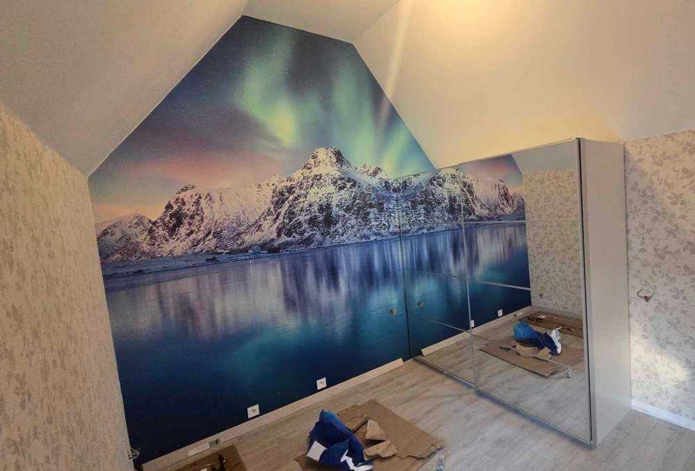 Des aurores boréales au-dessus d'un océan et de montagnes gelés