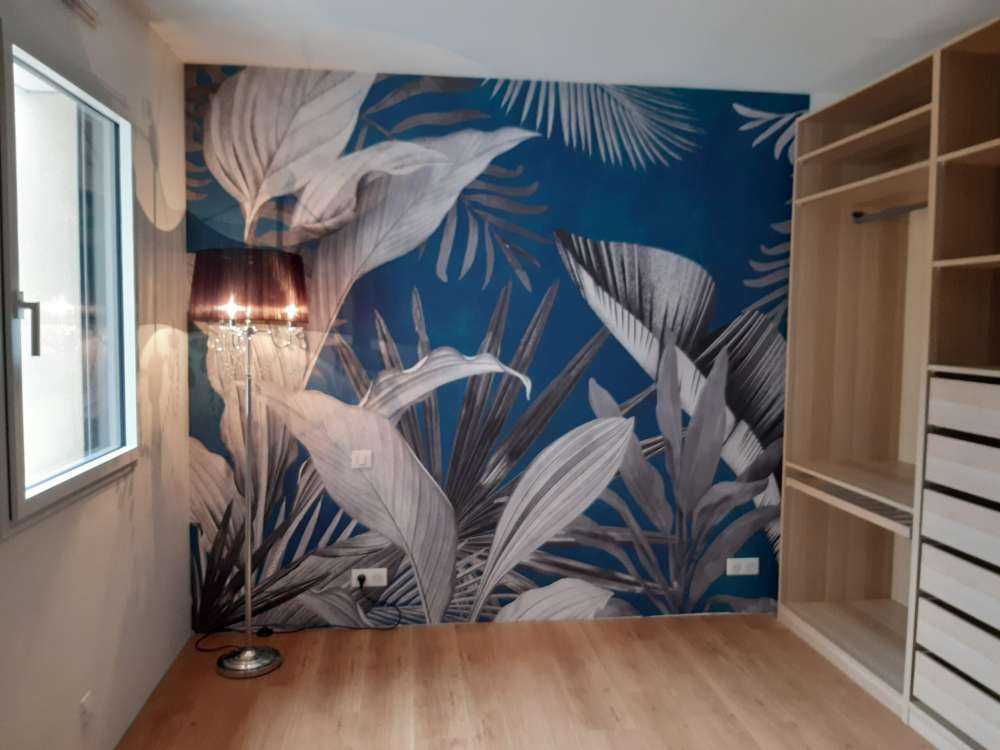 Feuilles tropicales sur fond bleu canard