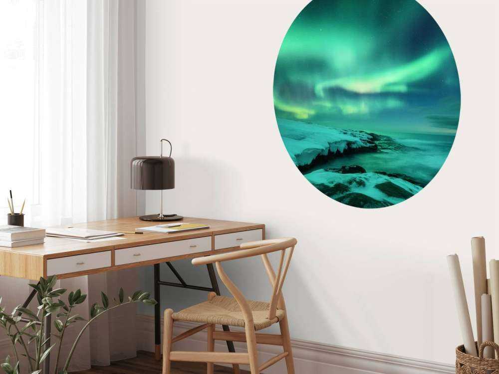 Des aurores boréales vertes au-dessus des rochers enneigés