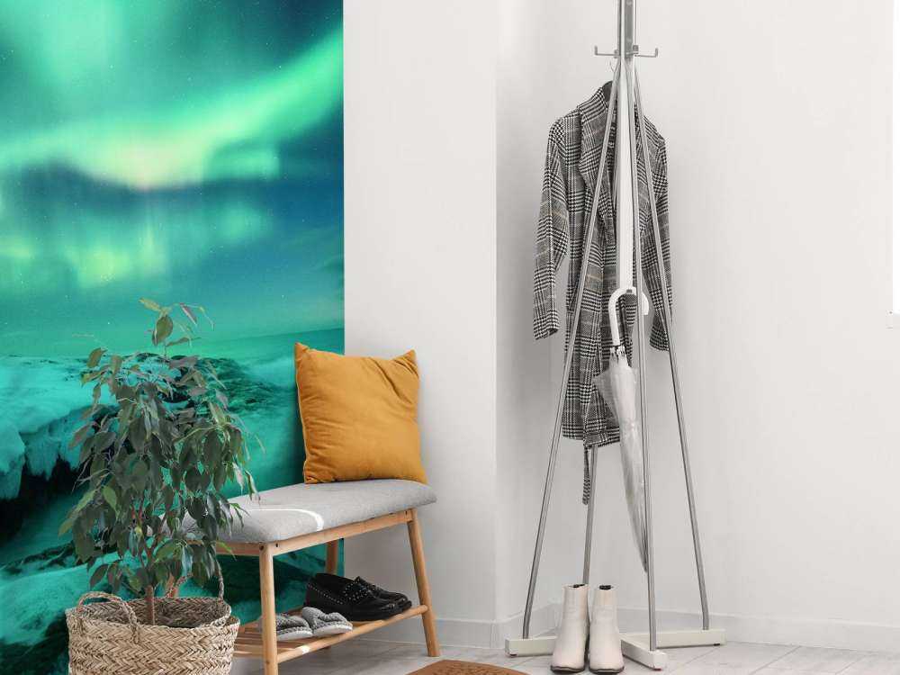 Des aurores boréales vertes au-dessus des rochers enneigés