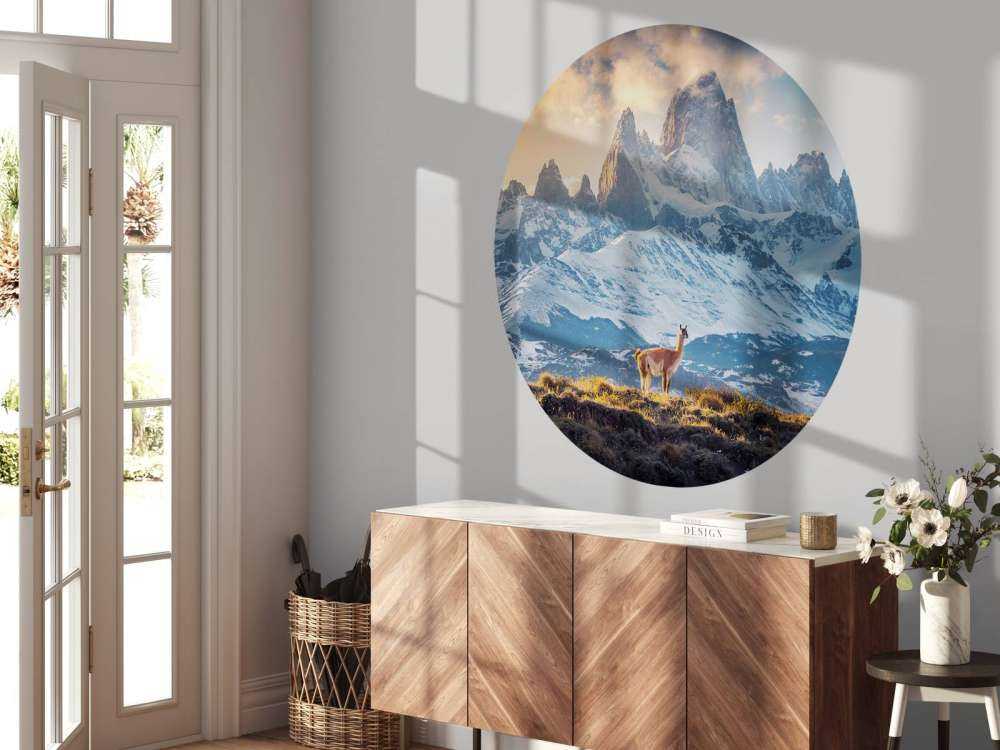 Guanaco près de sommets enneigés.