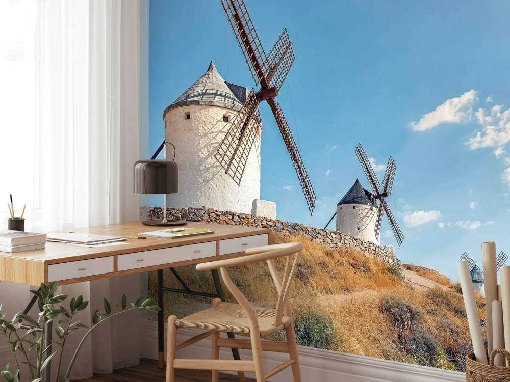 Colline d'été avec des moulins à vent blancs