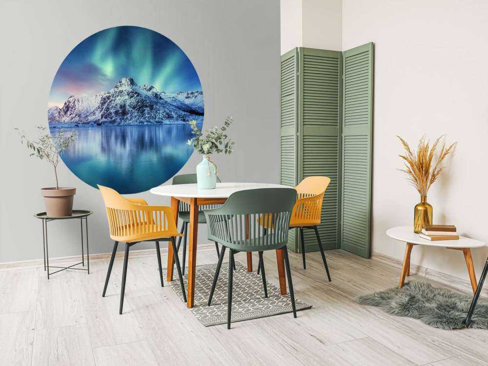 Des aurores boréales au-dessus d'un océan et de montagnes gelés