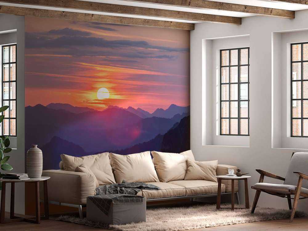 Coucher de soleil au-dessus de couches de montagnes violettes.