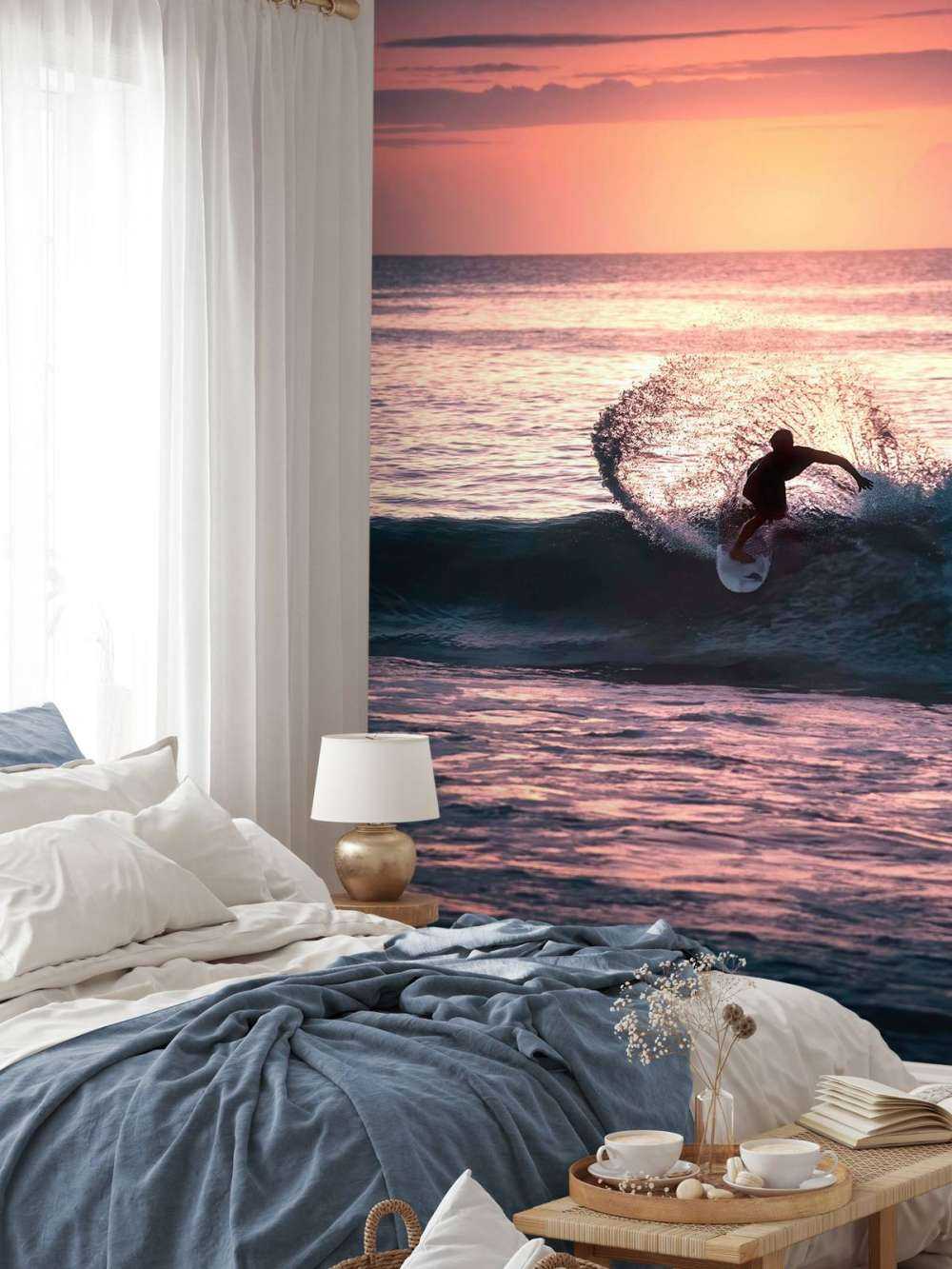 Surfeur dans la lueur rose du soir