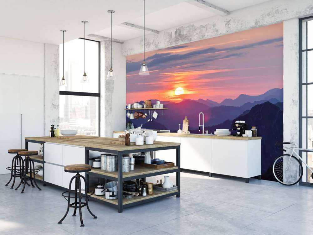 Coucher de soleil au-dessus de couches de montagnes violettes.