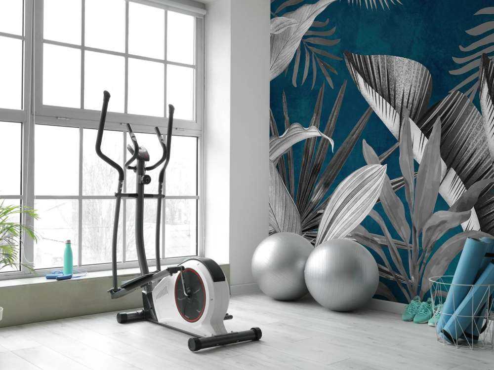 Feuilles tropicales sur fond bleu canard