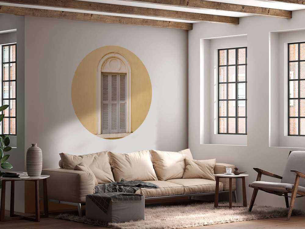 Fenêtre avec volets en bois sur un mur jaune