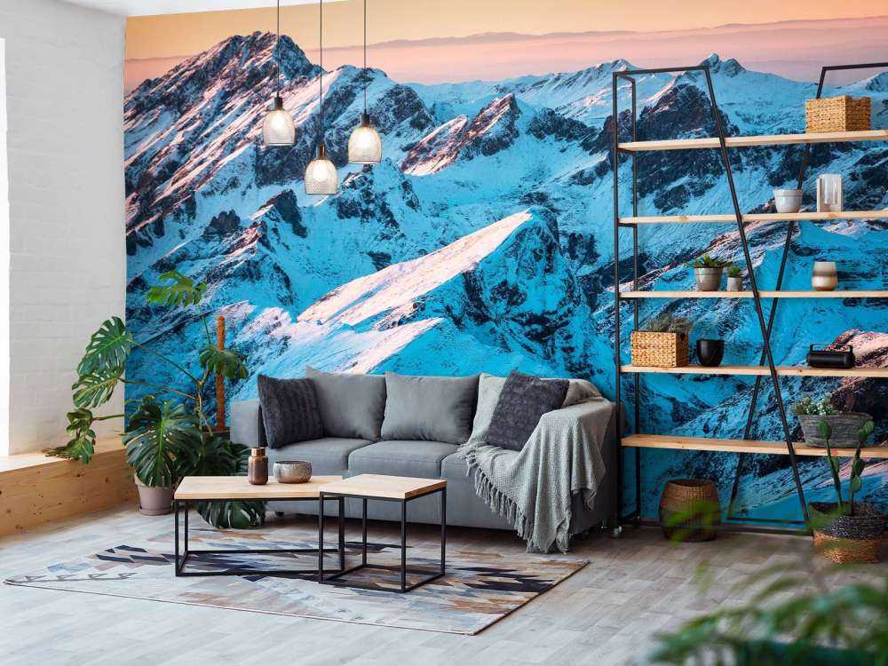 Lever du soleil sur un massif montagneux enneigé.