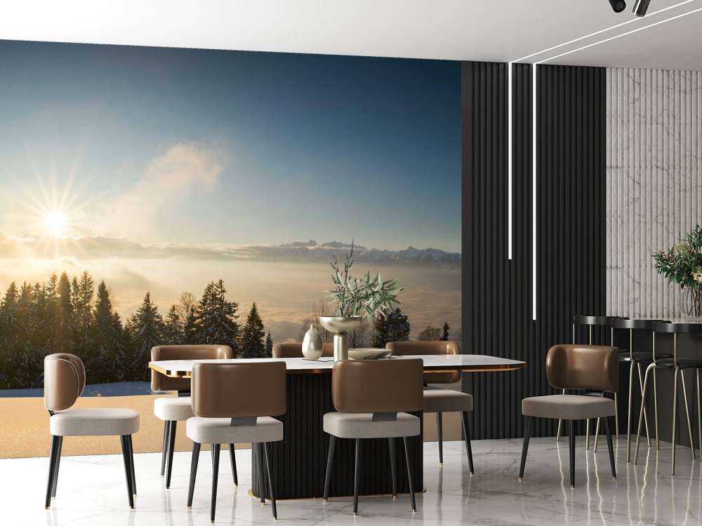 Lever de soleil au-dessus d'une forêt de sapins enneigée.