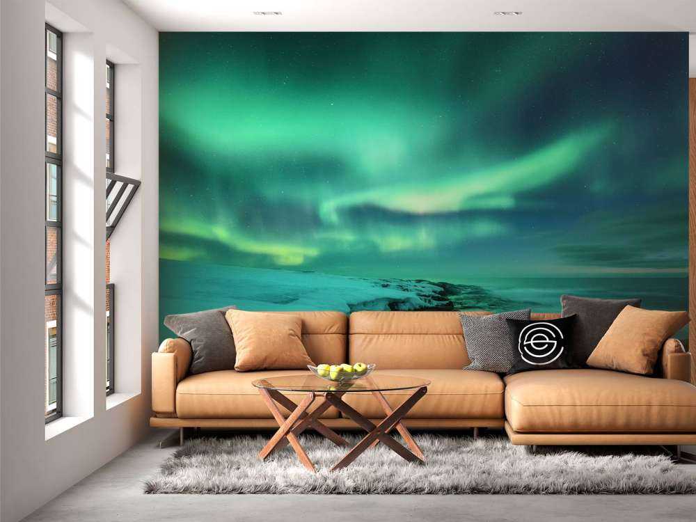 Des aurores boréales vertes au-dessus des rochers enneigés