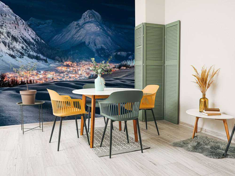 Village d'hiver sous la lumière de la lune dans une vallée alpine.