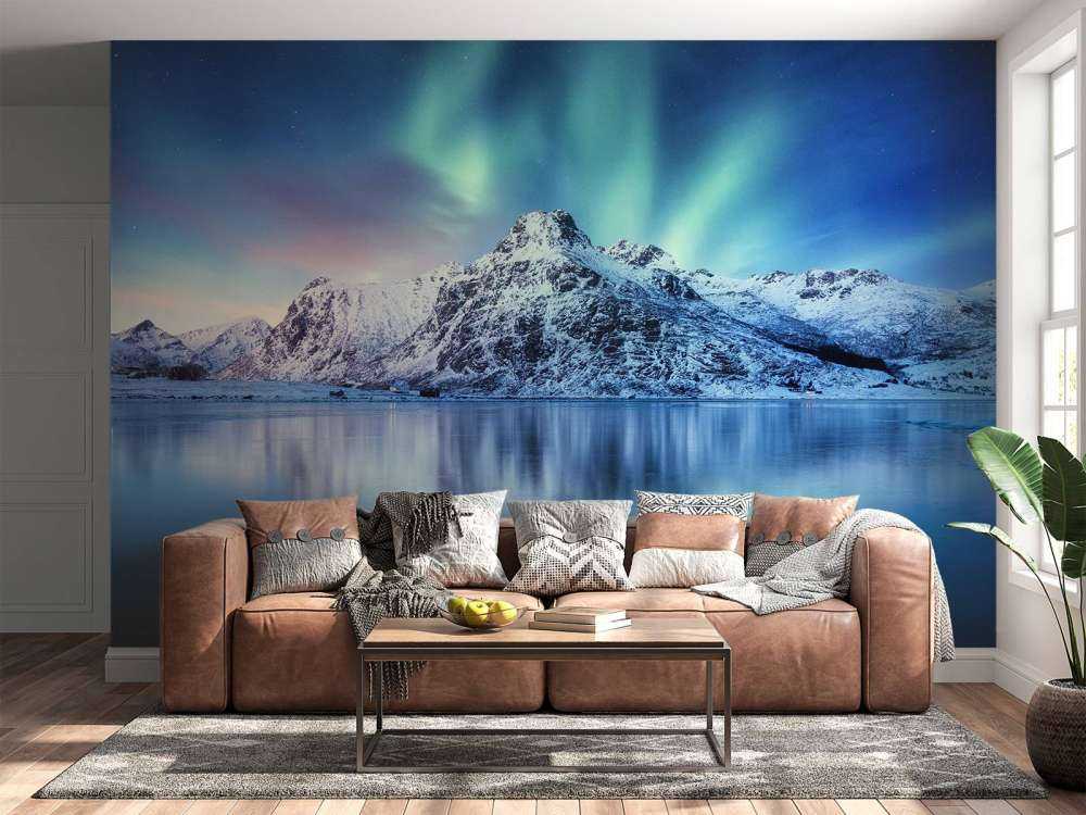 Des aurores boréales au-dessus d'un océan et de montagnes gelés