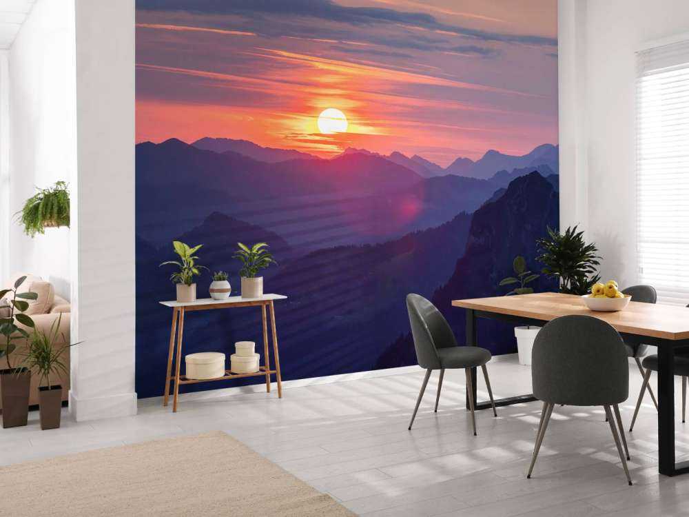 Coucher de soleil au-dessus de couches de montagnes violettes.