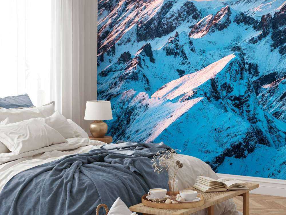 Lever du soleil sur un massif montagneux enneigé.