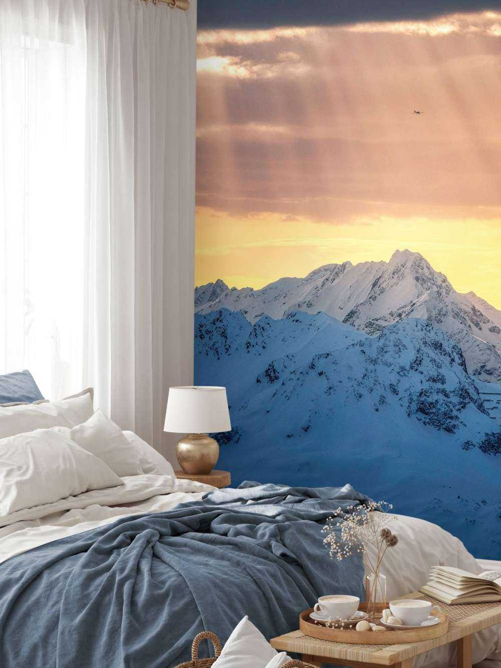 Rayons de soleil au-dessus des sommets enneigés