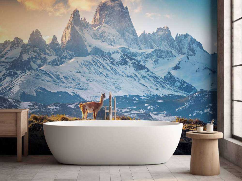 Guanaco près de sommets enneigés.