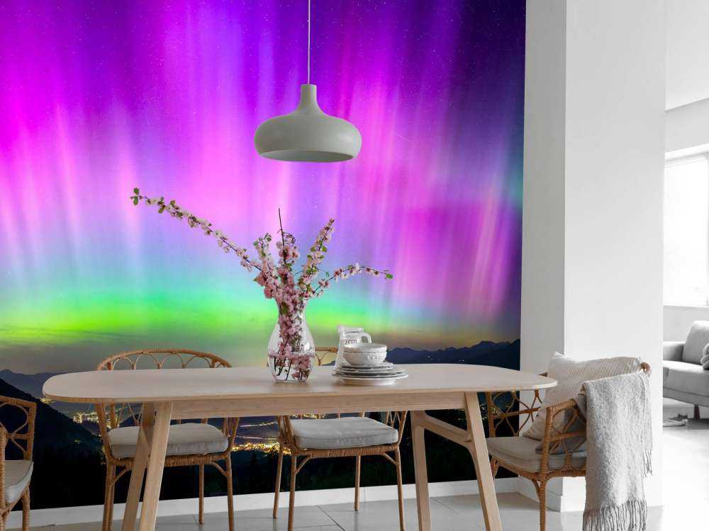 Aurore boréale au-dessus de la ville de montagne illuminée