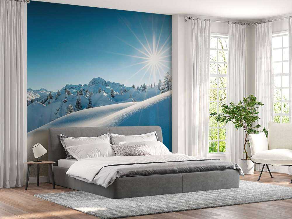 Lumière du soleil sur des collines enneigées scintillantes.