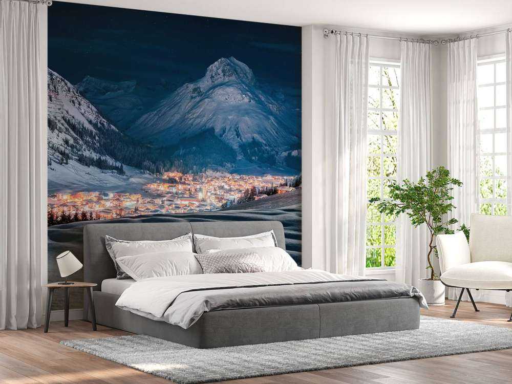 Village d'hiver sous la lumière de la lune dans une vallée alpine.