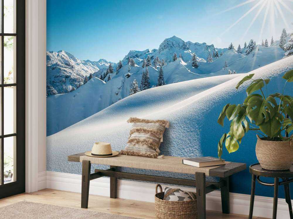 Lumière du soleil sur des collines enneigées scintillantes.