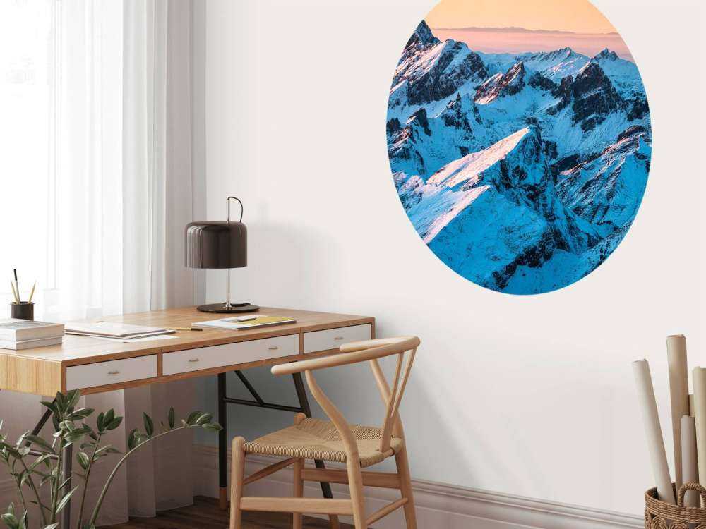 Lever du soleil sur un massif montagneux enneigé.