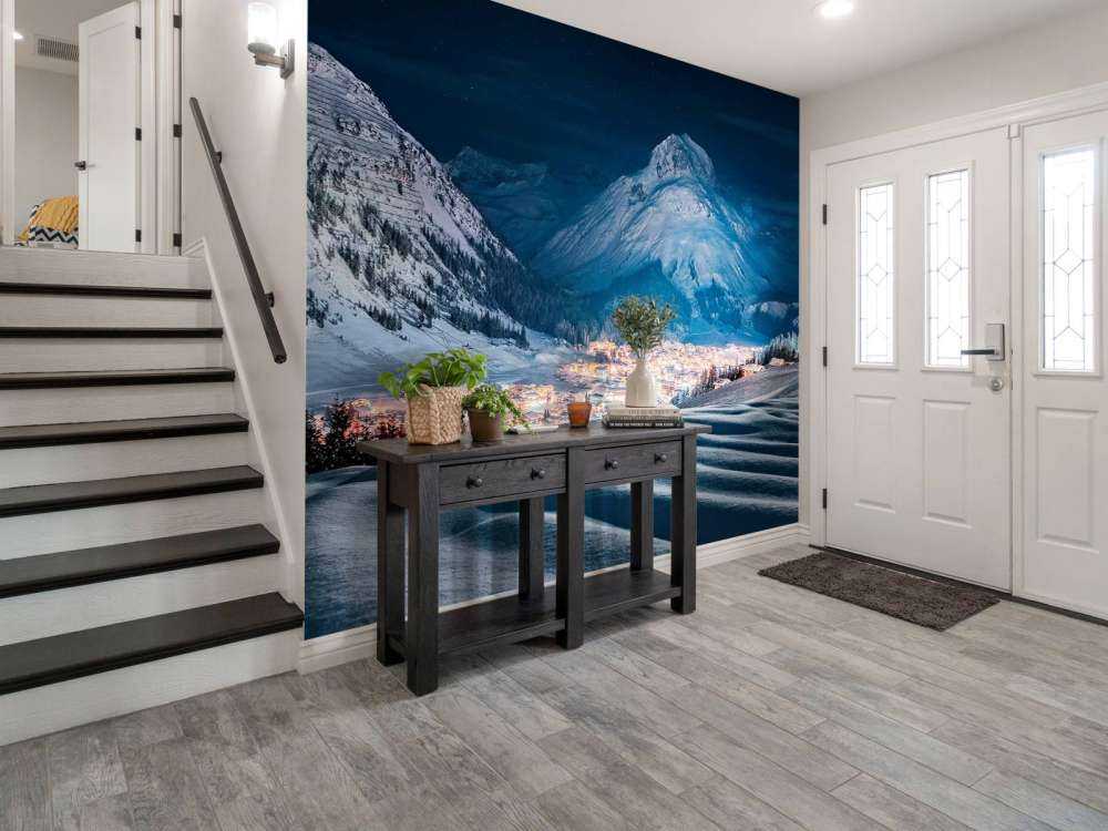 Village d'hiver sous la lumière de la lune dans une vallée alpine.