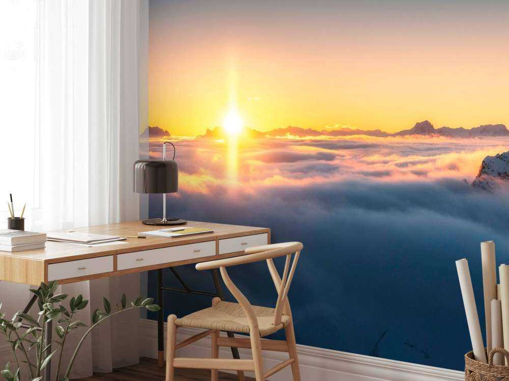Lever de soleil au-dessus de la mer de nuages et des sommets de montagne.