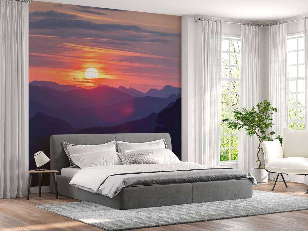 Coucher de soleil au-dessus de couches de montagnes violettes.