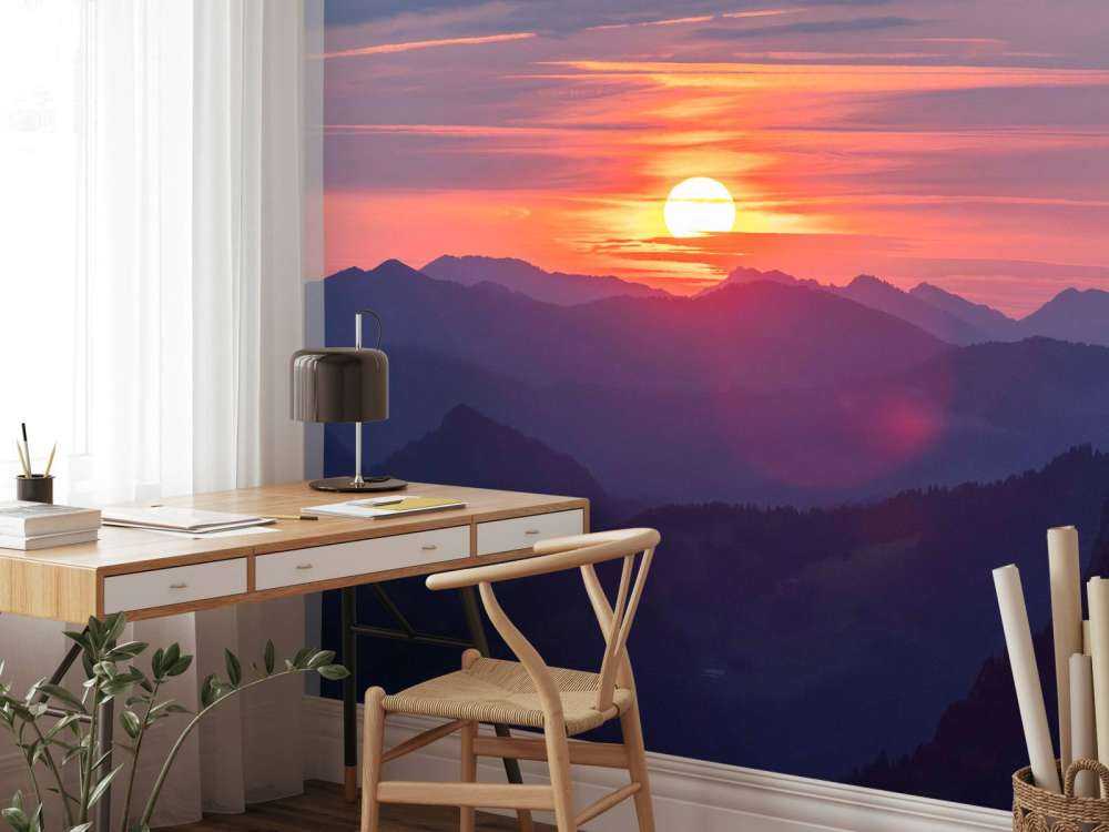 Coucher de soleil au-dessus de couches de montagnes violettes.