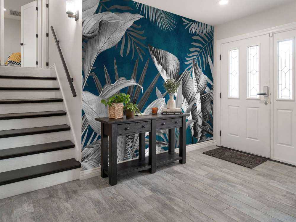 Feuilles tropicales sur fond bleu canard