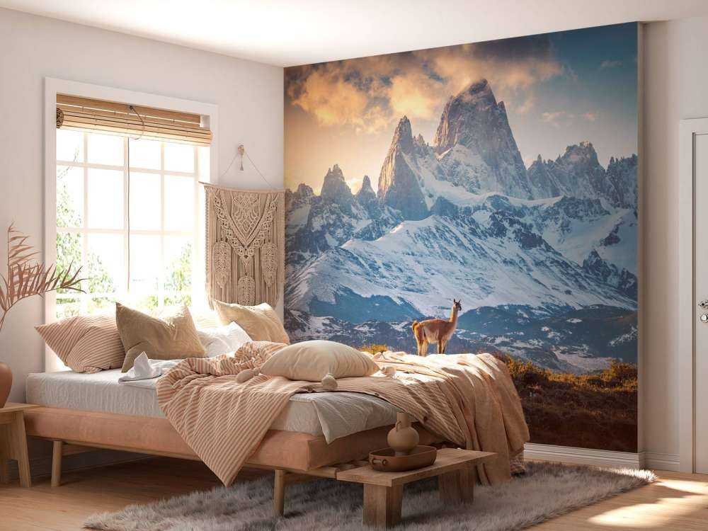 Guanaco près de sommets enneigés.