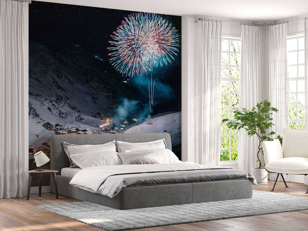 Feu d'artifice au-dessus d'un village de montagne en hiver