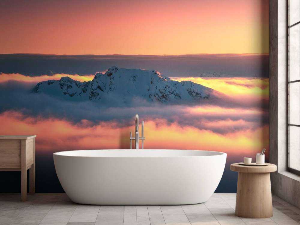 Sommet enneigé dans une mer de nuages