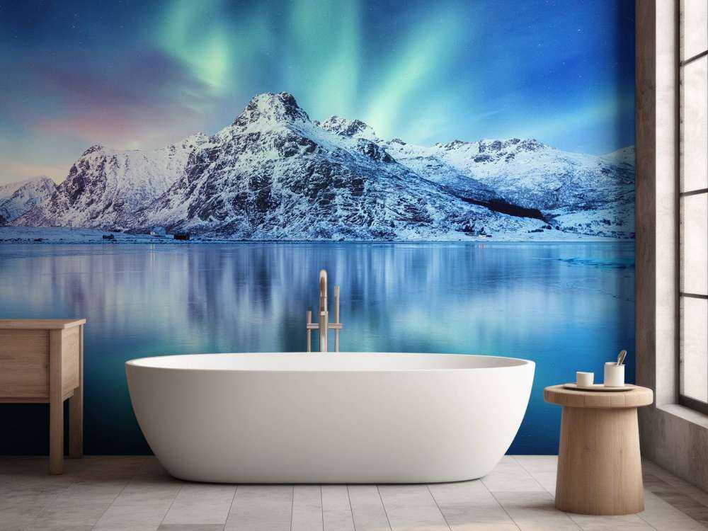 Des aurores boréales au-dessus d'un océan et de montagnes gelés