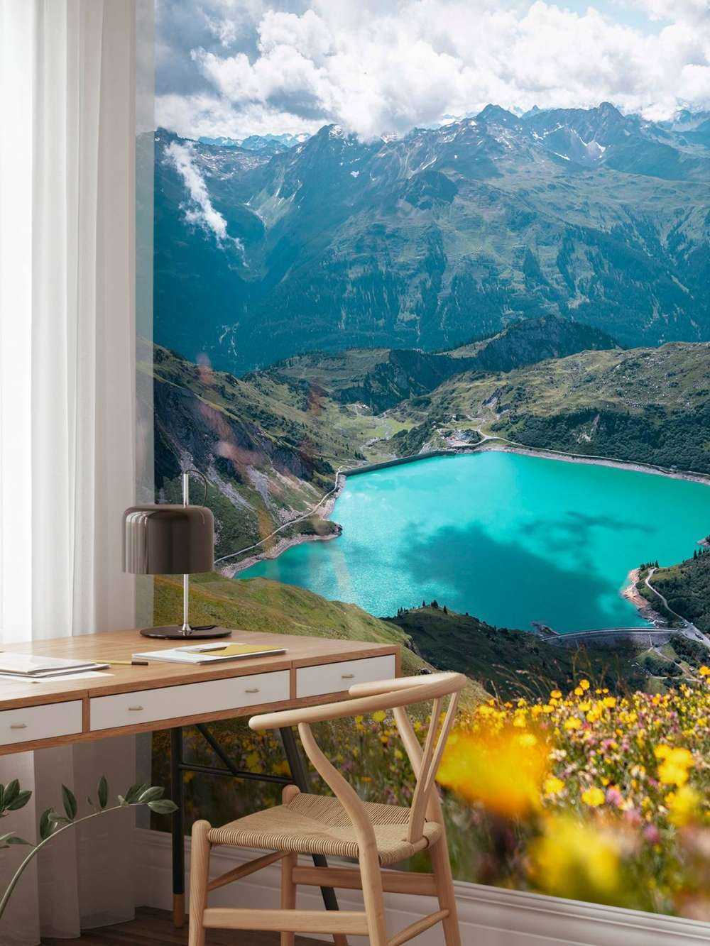 Champ de fleurs au bord d'un lac de montagne turquoise.