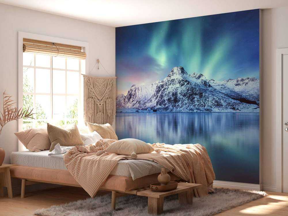 Des aurores boréales au-dessus d'un océan et de montagnes gelés