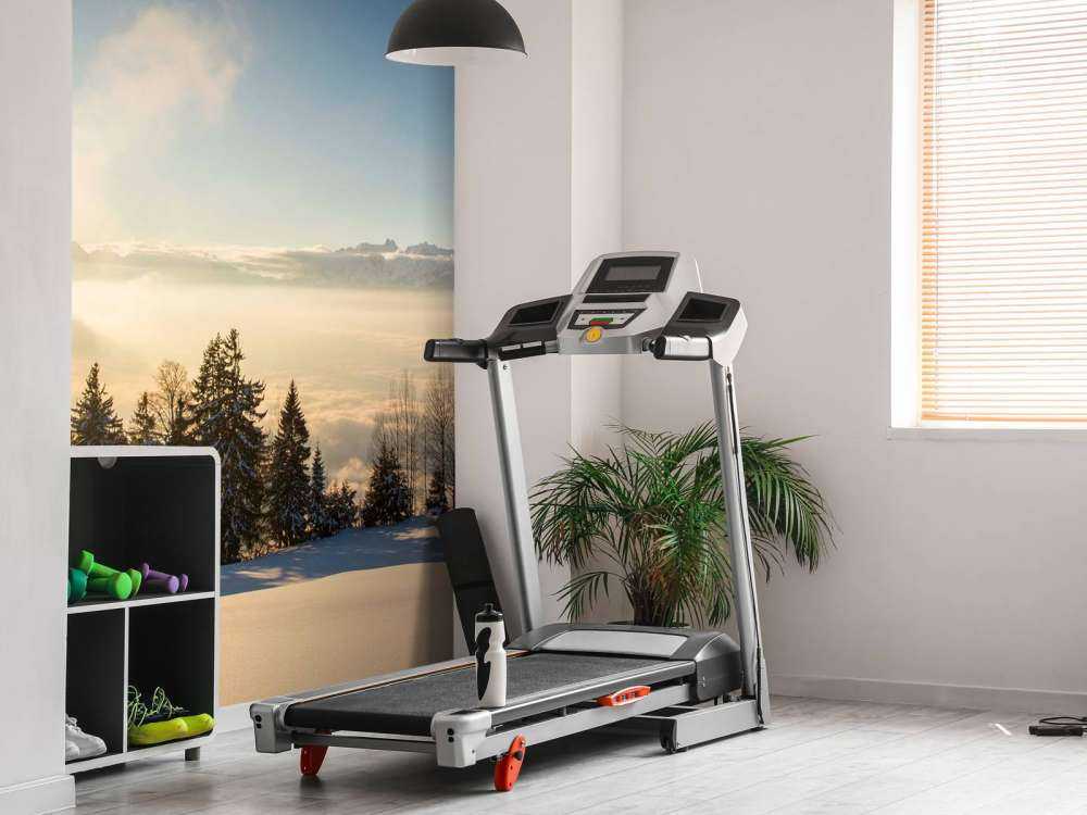 Lever de soleil au-dessus d'une forêt de sapins enneigée.