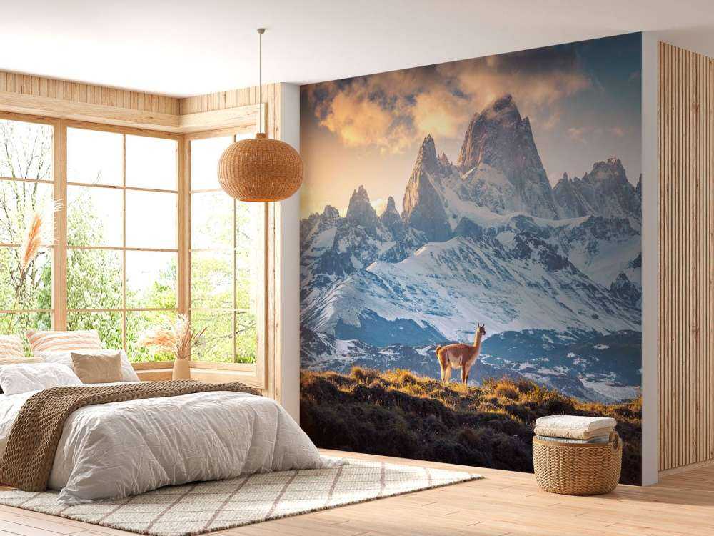 Guanaco près de sommets enneigés.