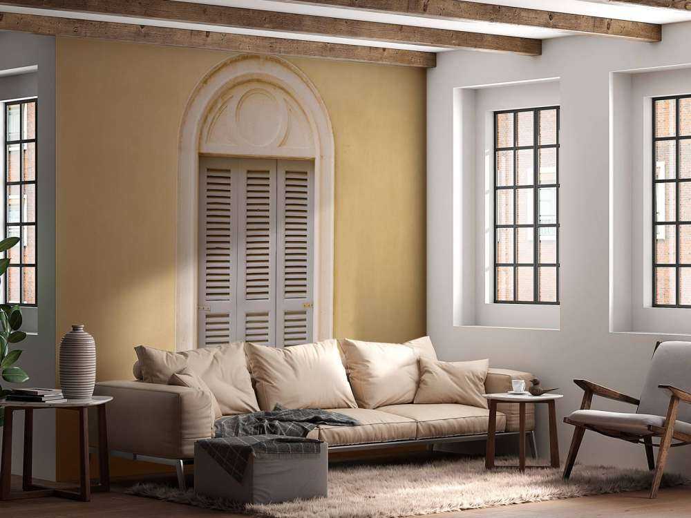 Fenêtre avec volets en bois sur un mur jaune