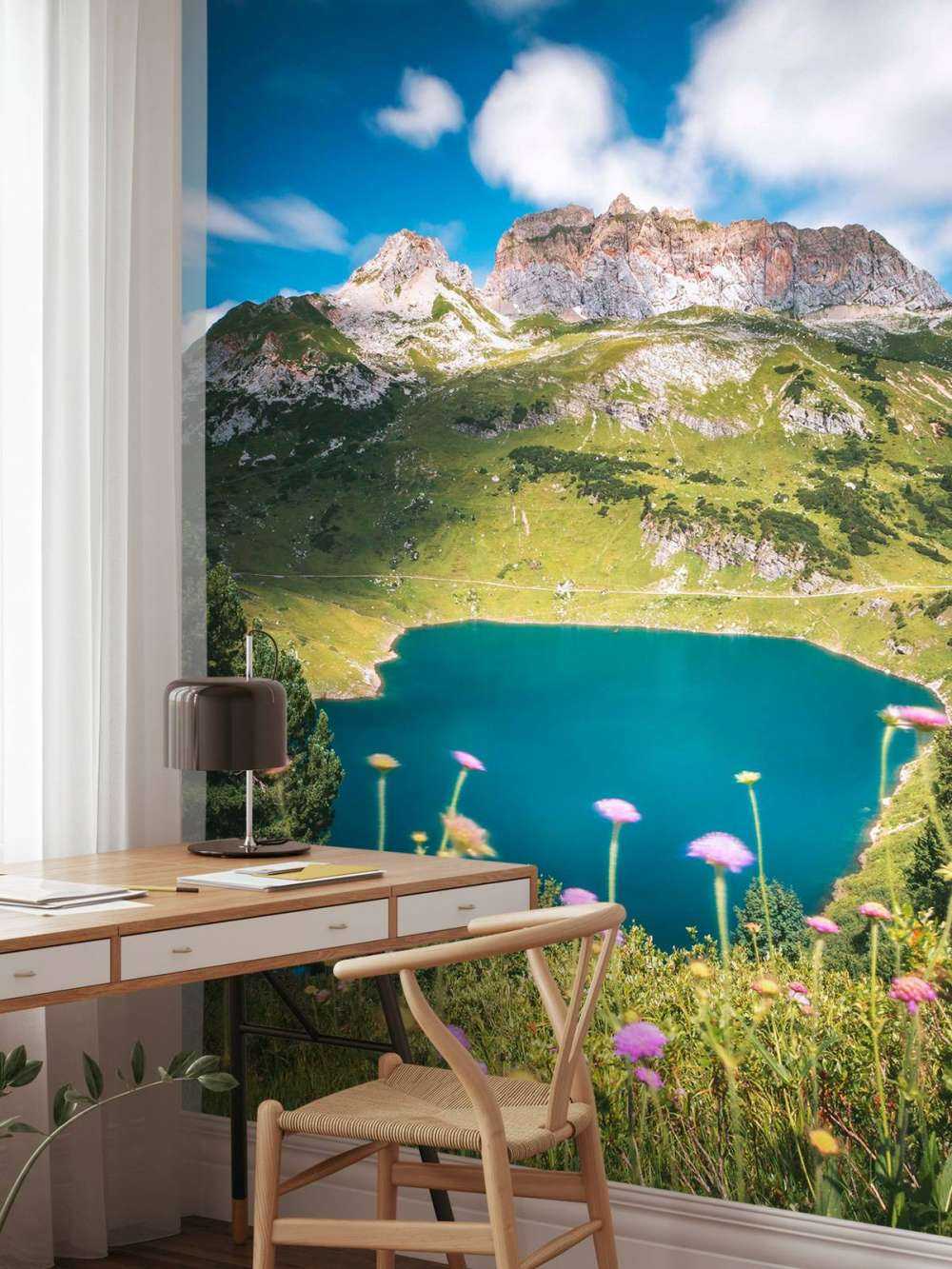 Pré fleuri au bord d'un lac de montagne clair