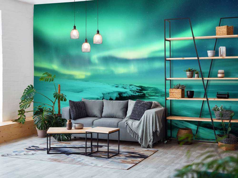 Des aurores boréales vertes au-dessus des rochers enneigés